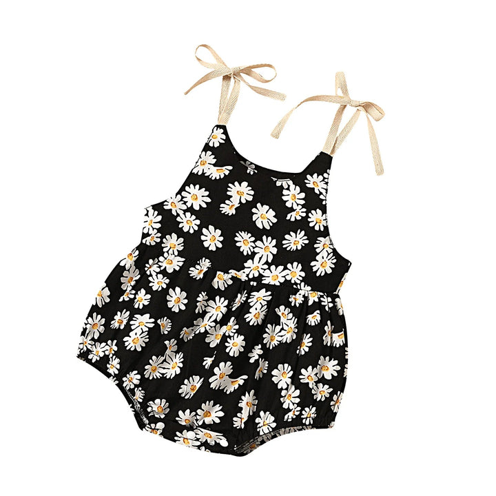 Black floral baby romper shown at an angle with beige shoulder ties