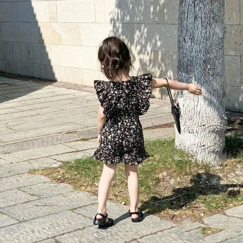 Rear view of a child wearing the black floral top and matching shorts outdoors