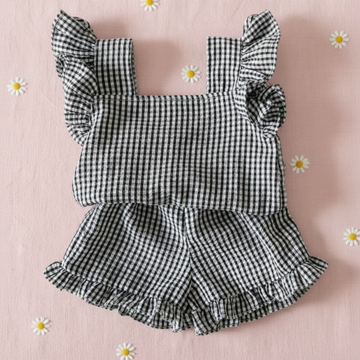Black gingham ruffle top and matching bloomers on a pink daisy-print background
