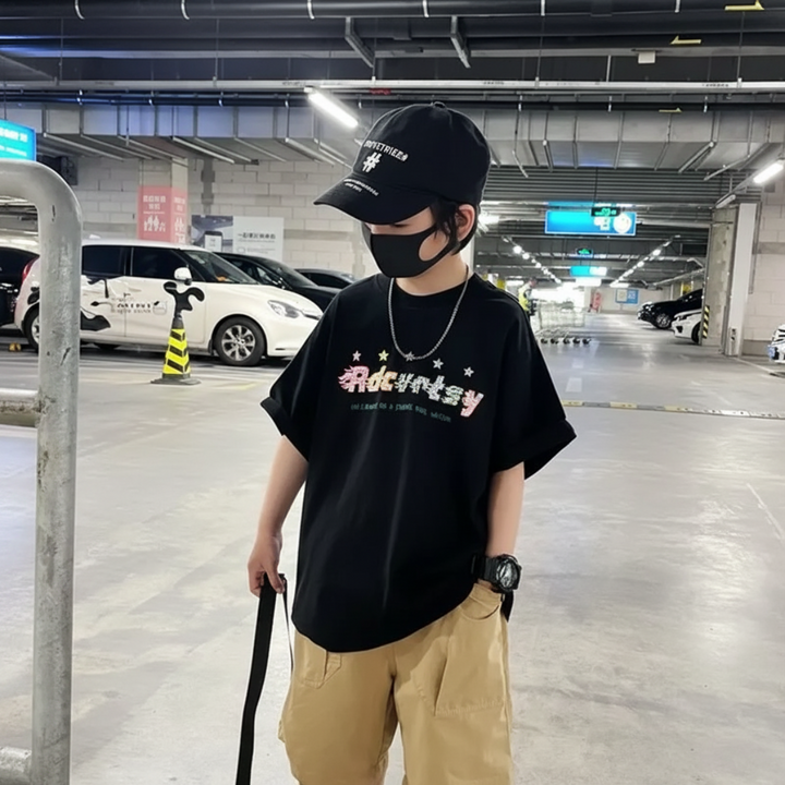 Black graphic T-shirt styled with tan shorts and a black cap