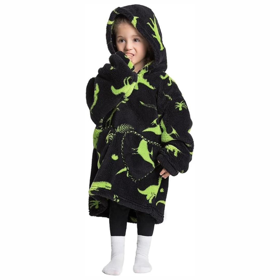 Child wearing a black hooded blanket with green dinosaur prints