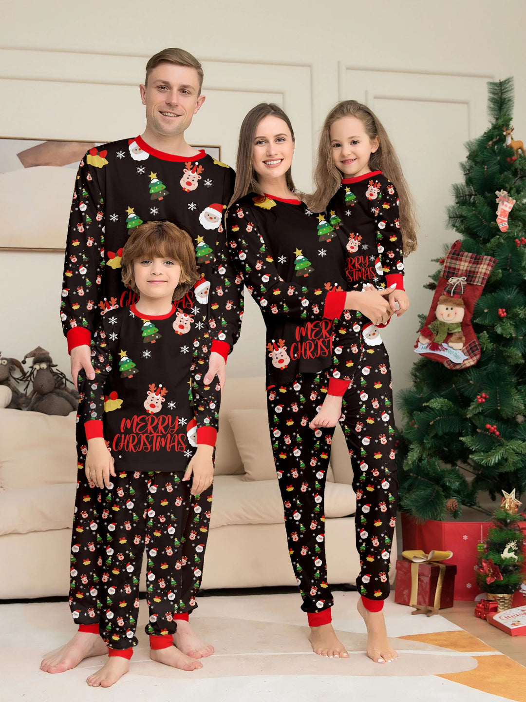 Two adults and two children wearing black Christmas pajamas with red trim beside a decorated tree