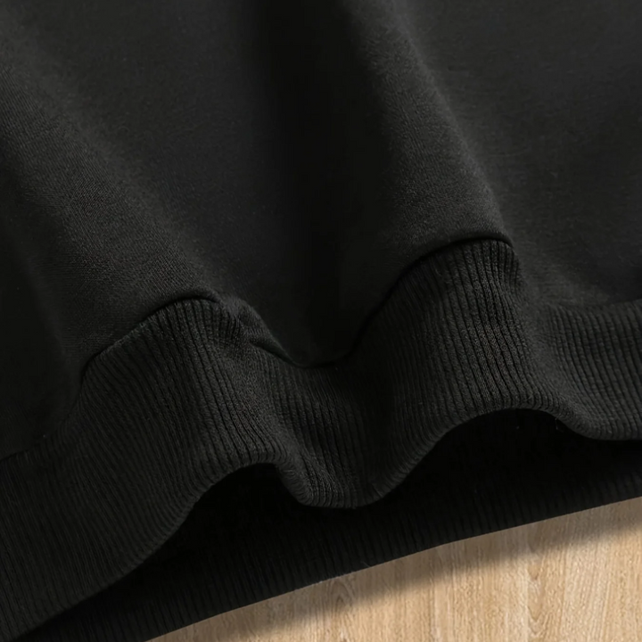 Close-up of the ribbed bottom hem on the black hoodie.