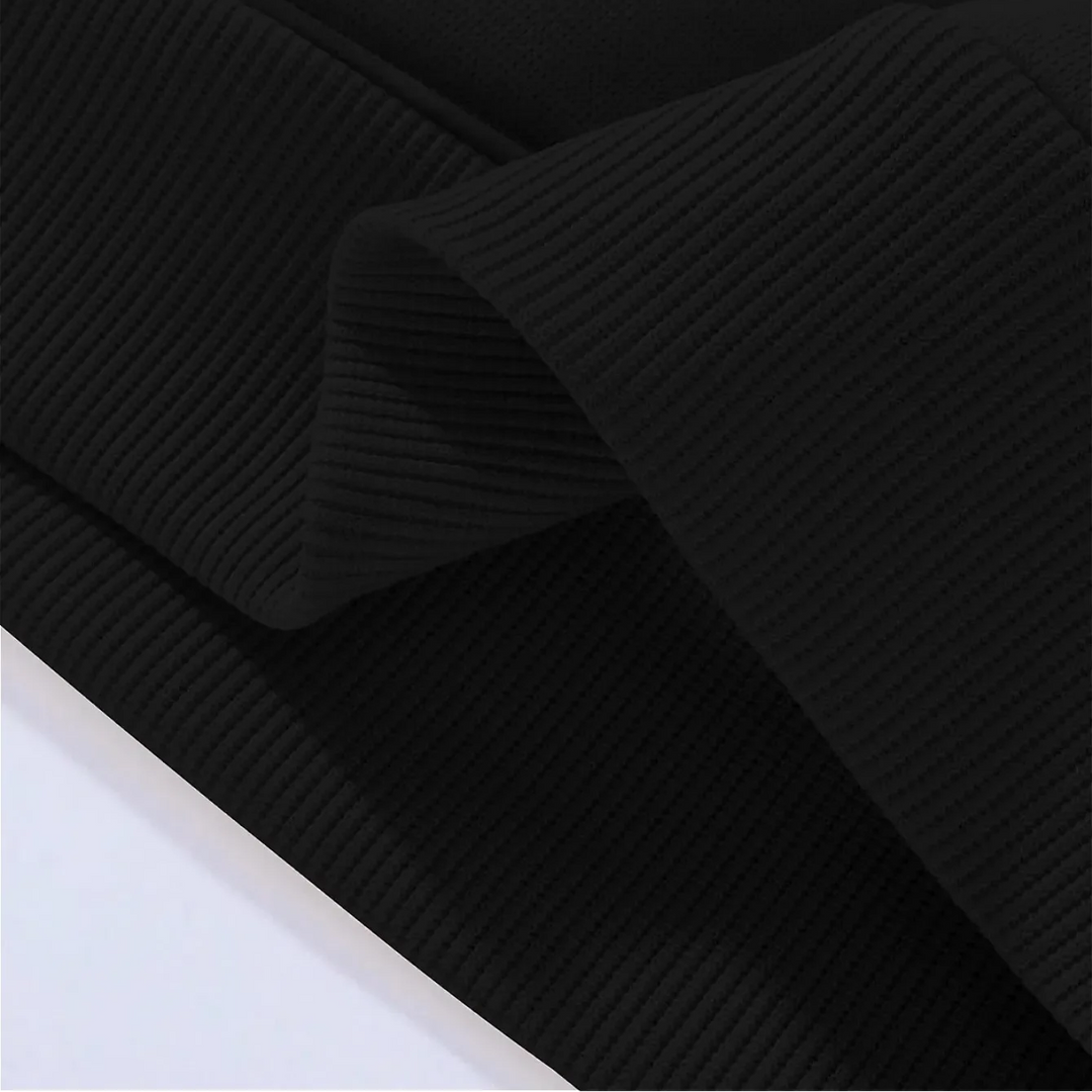 Ribbed sleeve cuff and waistband detail on the black hoodie.