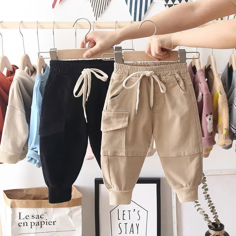 Front view of black and khaki boys' cargo pants with elastic drawstring waistbands