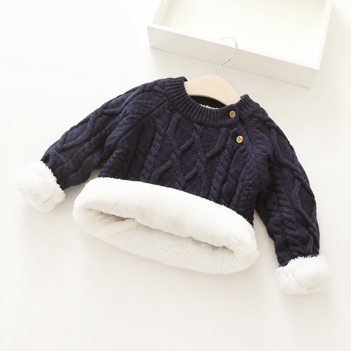 Black cable-knit sweater with the hem and cuffs folded back to show plush white lining.