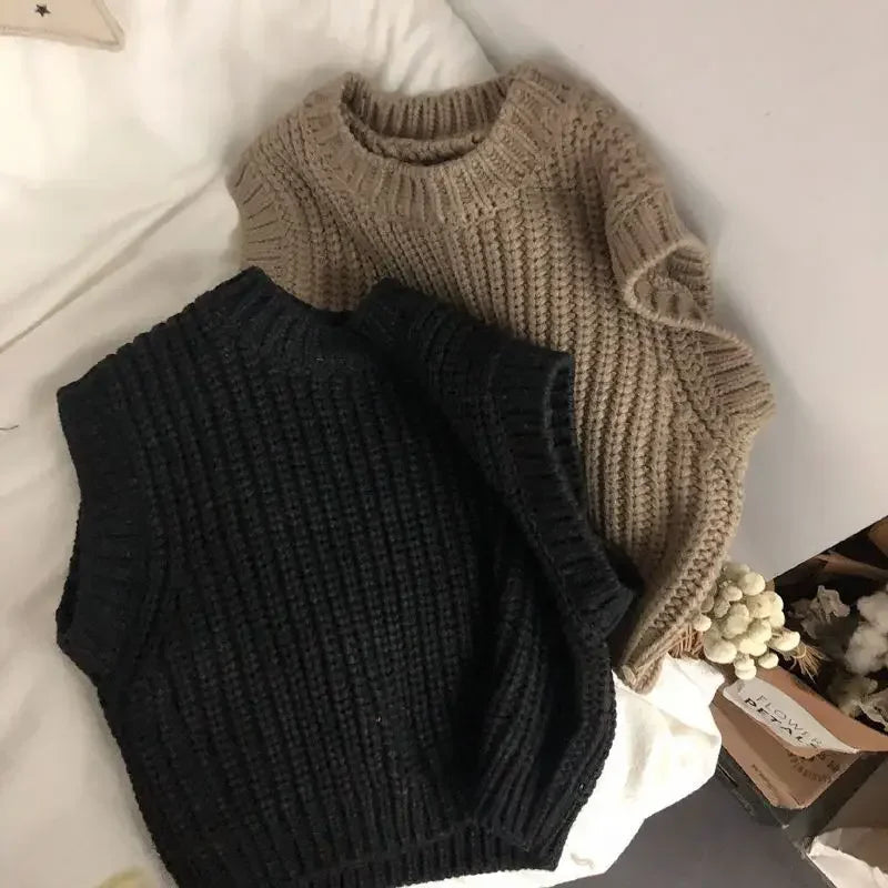 Black knit sweater vest with a brown vest behind it, showing their sleeveless shapes