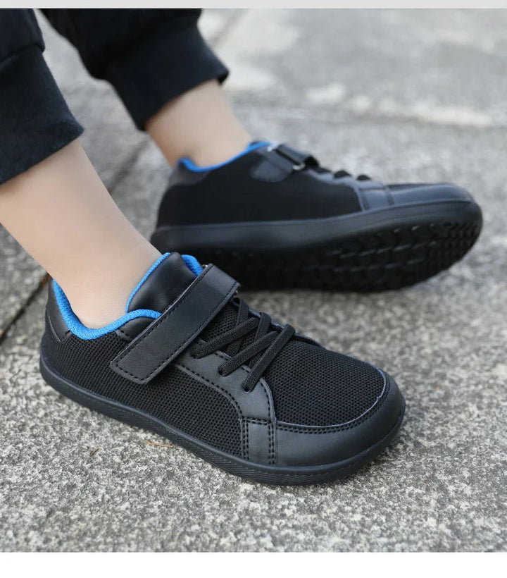 Black mesh sneakers with blue lining shown on feet, with one outsole visible