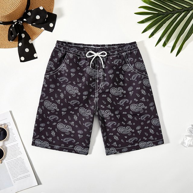 Black swim trunks with a light paisley pattern and white drawstring.
