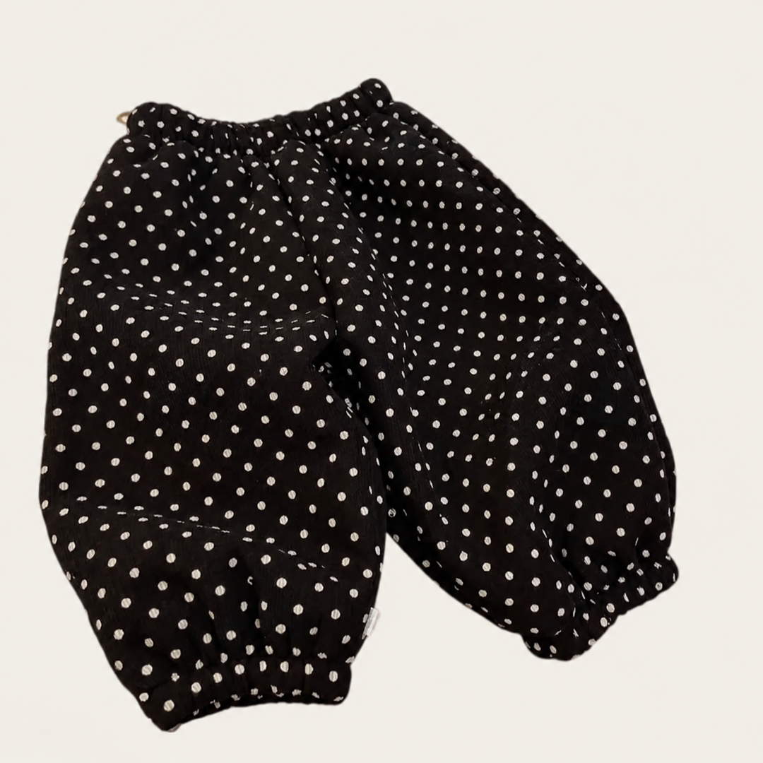 Black polka-dot pants with a relaxed fit and elastic ankle cuffs