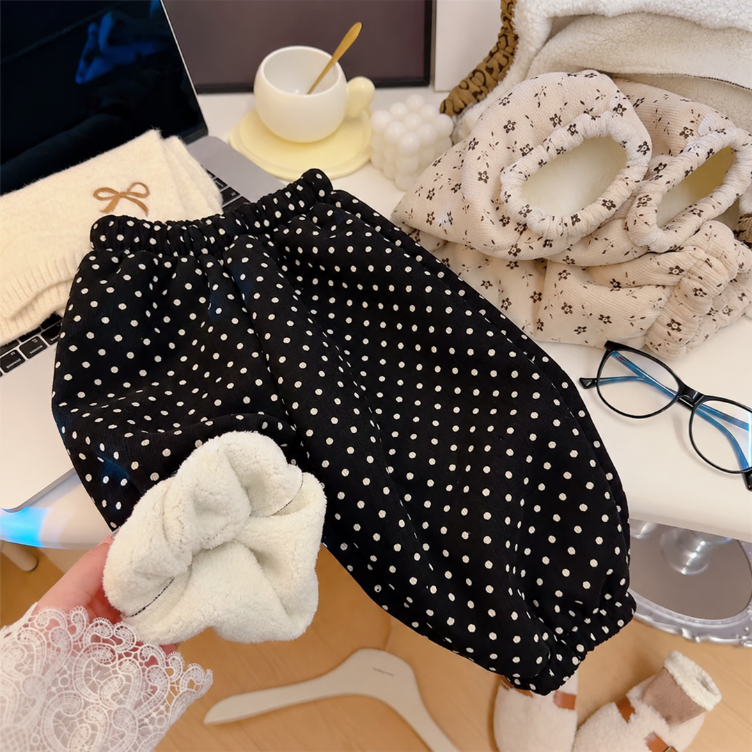 Black polka-dot pants with one cuff turned back to reveal the fleece lining