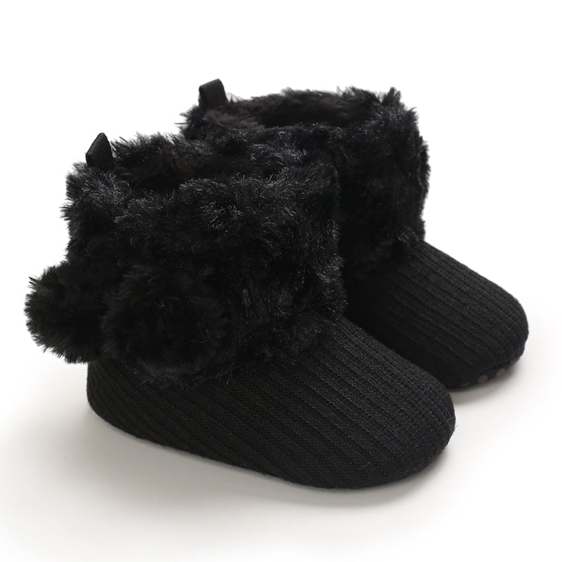 Black baby boots with ribbed uppers and fluffy pom-pom accents