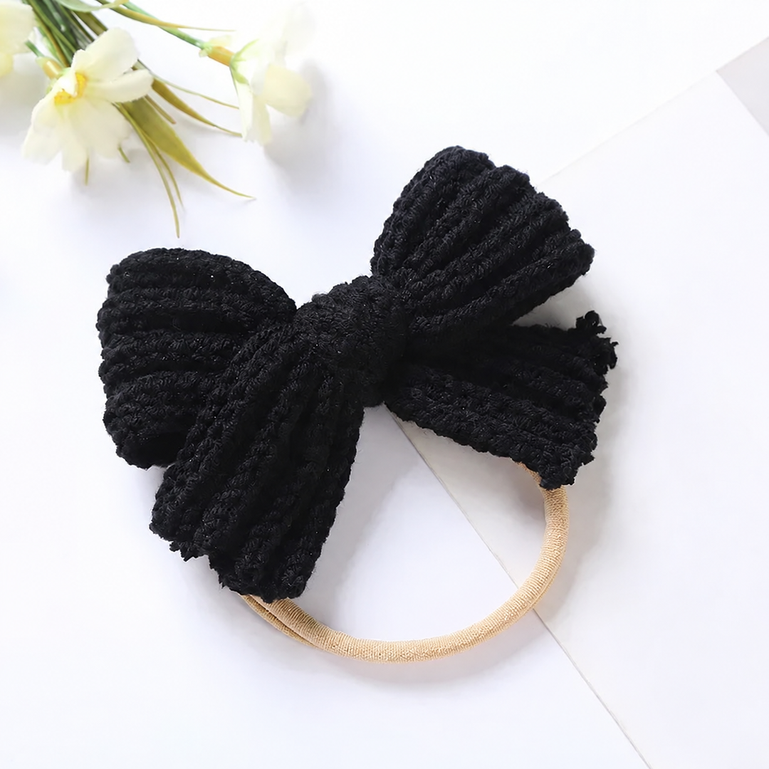 Black ribbed knit bow headband with a beige stretch band