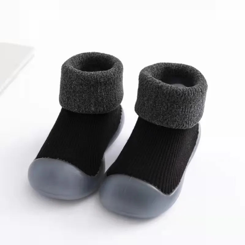 Black sock shoes with charcoal folded cuffs and gray rubber soles.