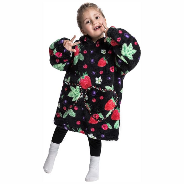 Child wearing a black hooded blanket with red strawberry prints