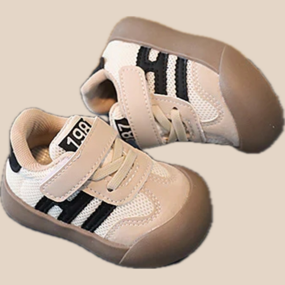 Black-striped kids' sneaker pair showing hook-and-loop straps, mesh panels, and rounded toes