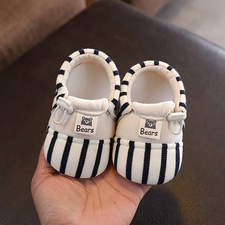 Pair of black striped baby shoes with elastic closures and bear details