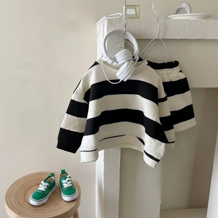 Black-and-cream striped long-sleeve top with matching shorts on a hanger