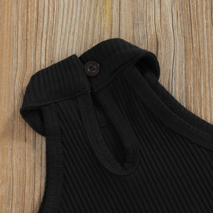 Button closure and keyhole opening at the back of the black ribbed top.