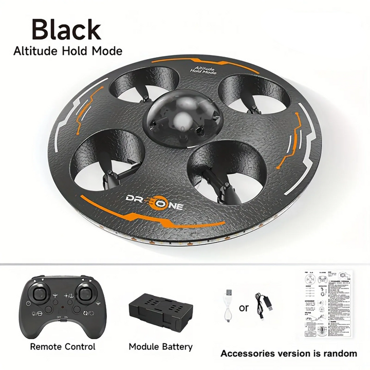 Black UFO drone shown with a remote control, modular battery, charging cable and instructions