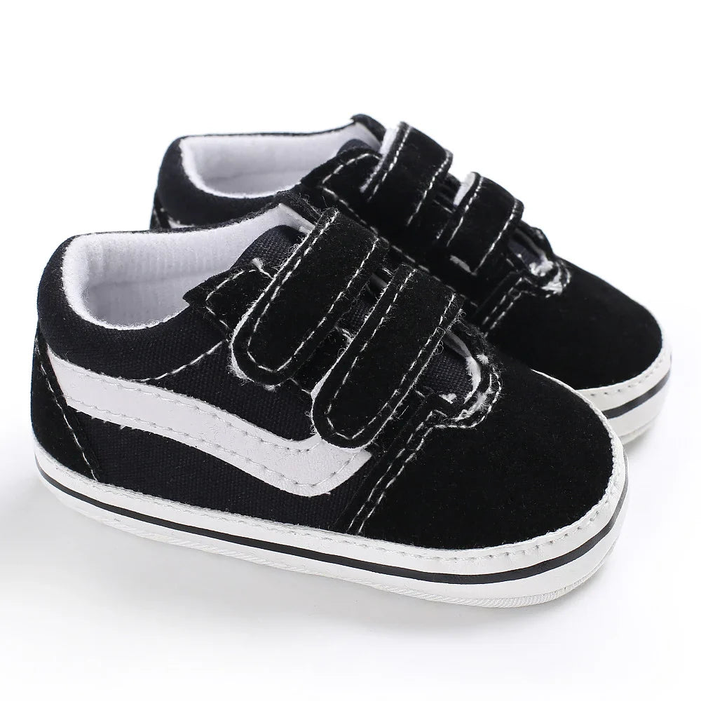 Pair of black-and-white baby sneakers with double hook-and-loop straps