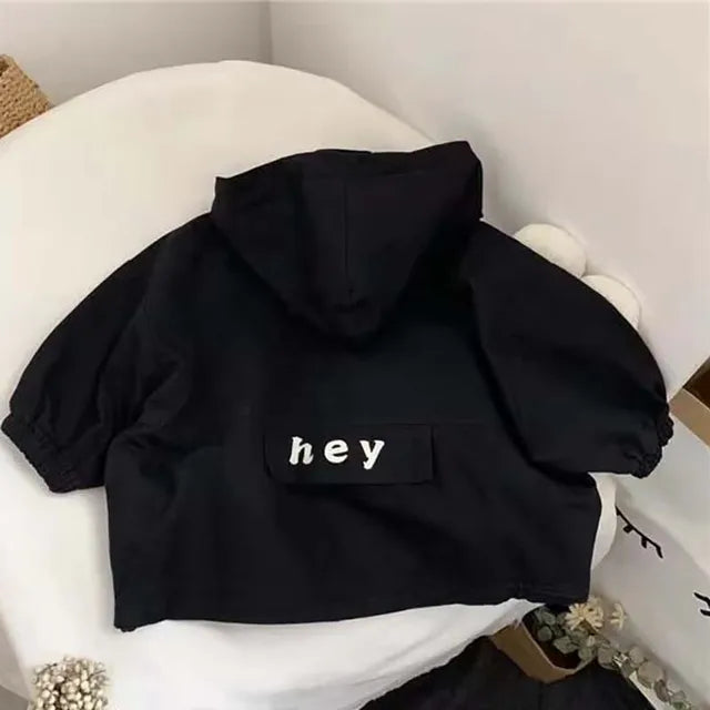 Black hooded jacket shown from the back with a lettered panel