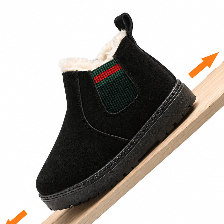 Black winter boot resting on an inclined wooden board, showing its side panel and rubber sole.