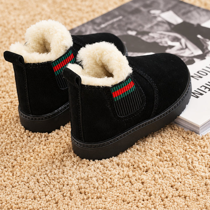 Black plush-lined winter boots viewed from the side and back on a beige carpet.