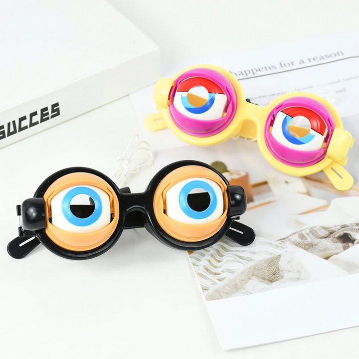 Black and yellow toy glasses with oversized blue eyes on a tabletop