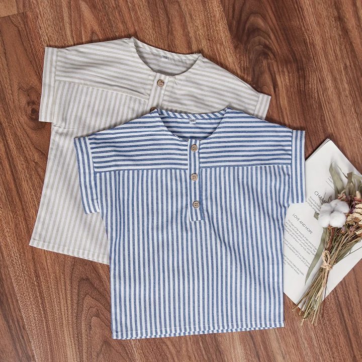 Blue and gray striped short-sleeve shirts laid on a wooden floor