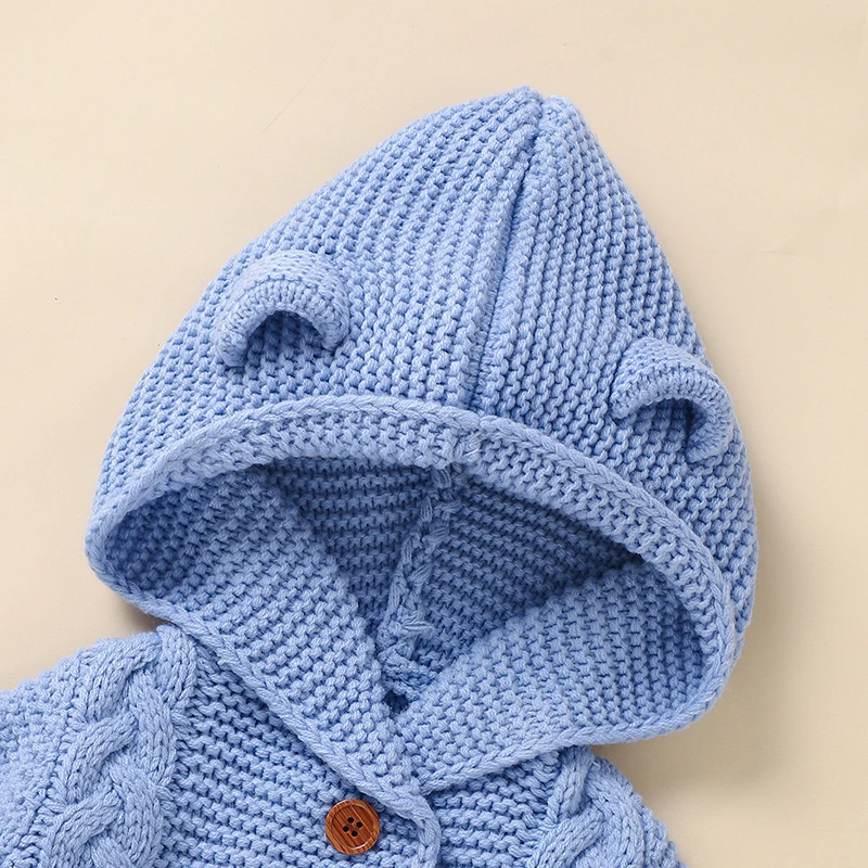 Close-up of the blue knitted hood with small ears and a button at the neckline
