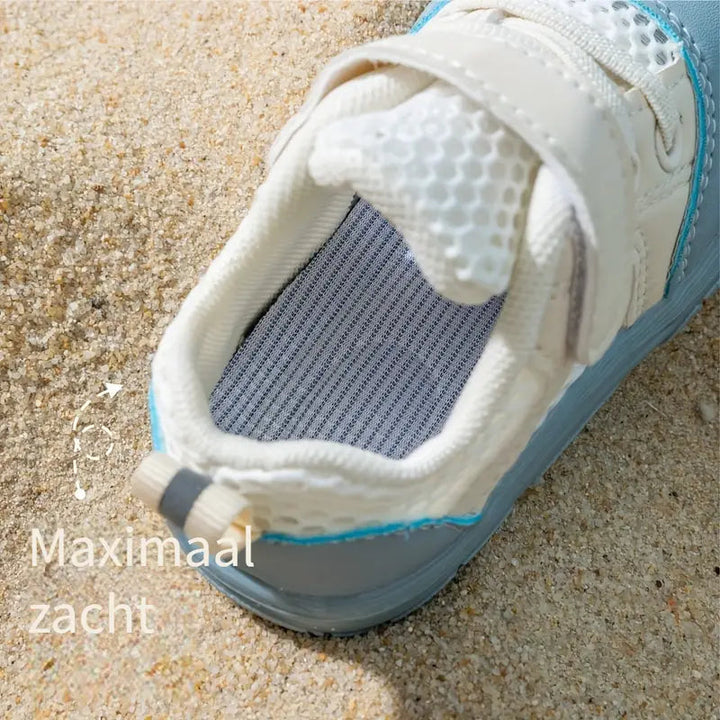 Top view of a blue mesh baby shoe showing its padded opening and striped insole