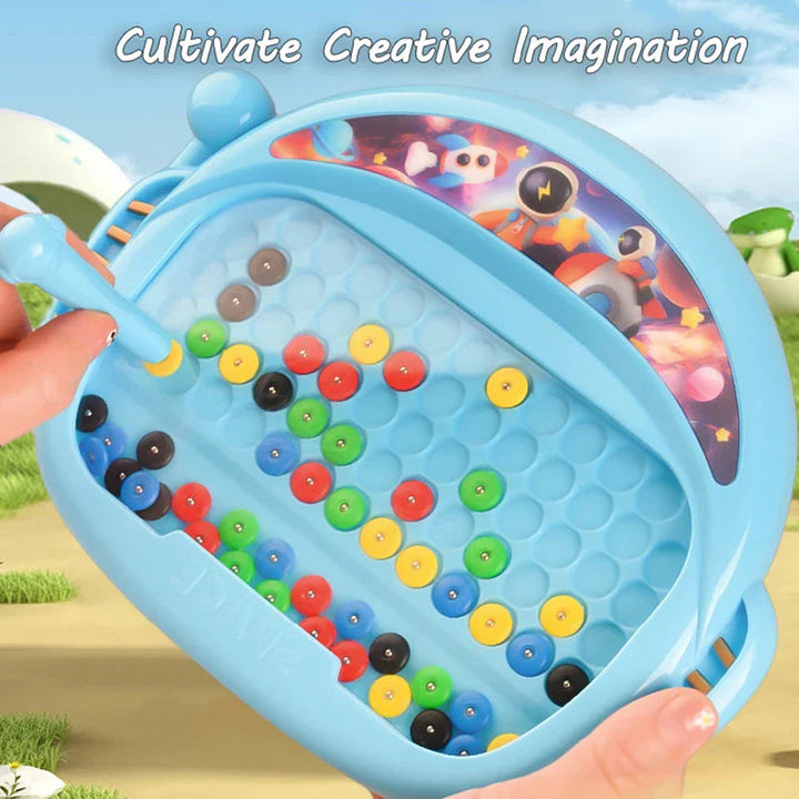 Hands holding a blue magnetic board while guiding colorful beads with the pen