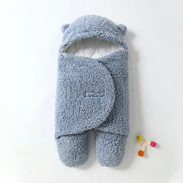 Blue sherpa baby wrap blanket with a bear-ear hood, overlapping wings, and separate foot sections.