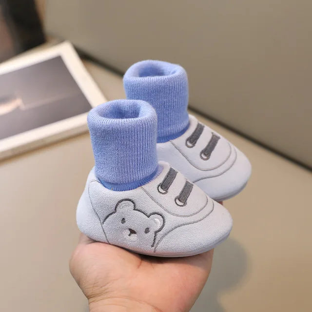 Pair of blue baby sock shoes with bear faces and sneaker-style stitching
