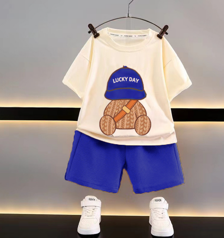 Cream T-shirt printed with a teddy bear in a blue cap, paired with blue shorts
