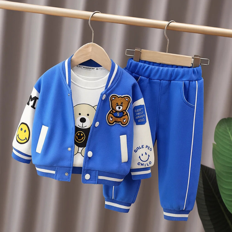 Blue-and-white bear-patch varsity jacket, white graphic T-shirt, and matching blue pants