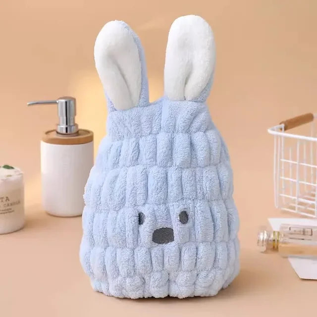 Blue microfiber hair-drying cap with white bunny ears on a bathroom counter