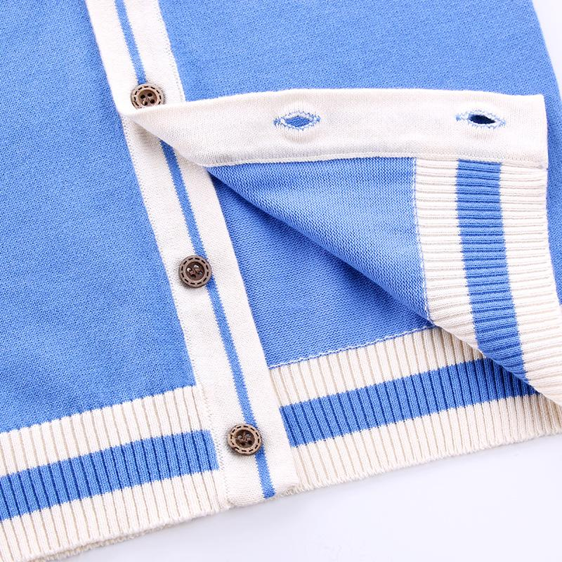 Blue cardigan close-up showing buttons, buttonholes, inner knit, and striped ribbed hem