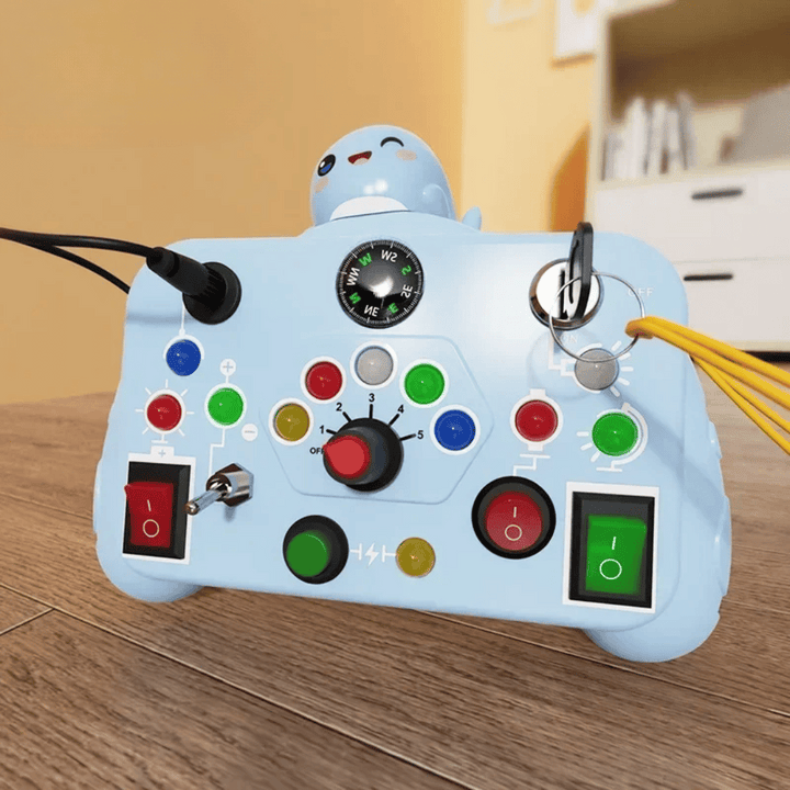 Blue activity board with a smiling character topper, dial, key, buttons, and switches