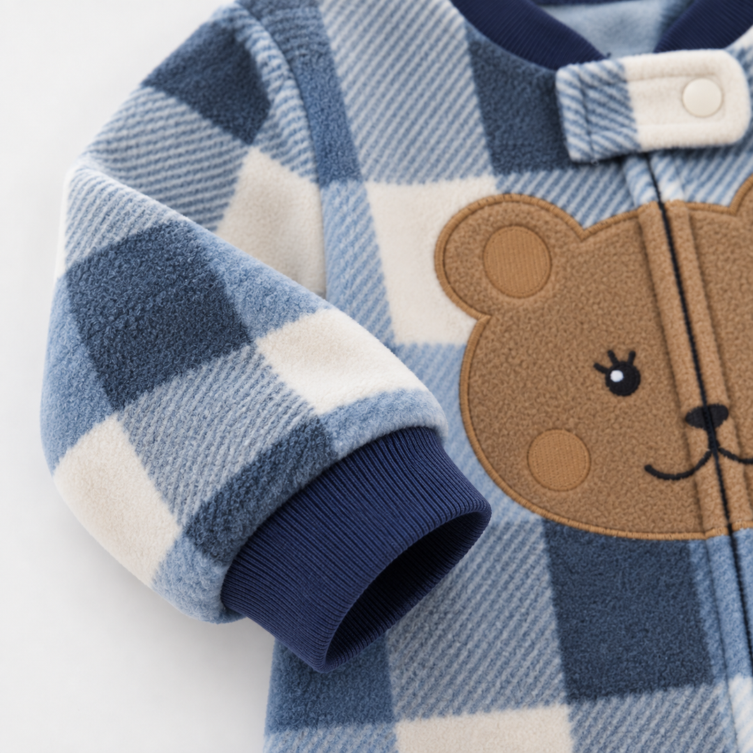 Close-up of a blue check fleece sleeve, navy cuff and bear chest design