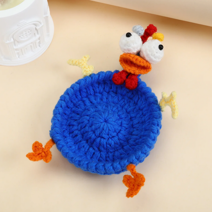 Blue chicken coaster with a round center, large eyes, red comb, and orange feet