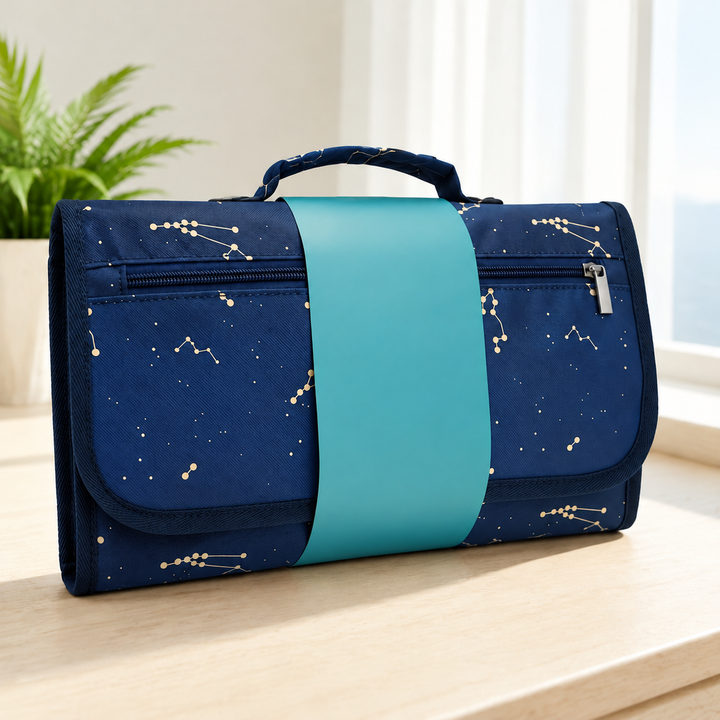Blue constellation-print changing mat with a teal band, handle, and front zipper.