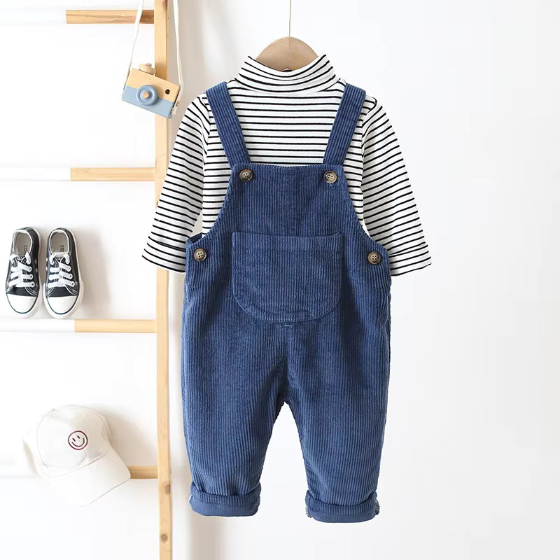 Blue corduroy overalls layered over a striped long-sleeve top on a hanger