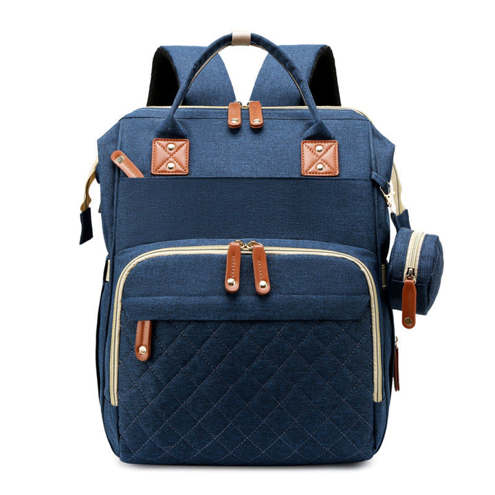 Blue diaper backpack with a quilted front pocket and round side pouch