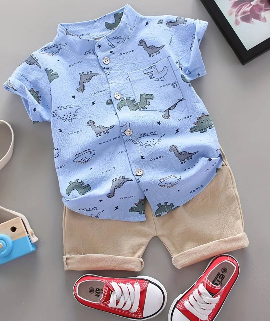 Front view of a blue dinosaur-print button-front shirt with beige cuffed shorts