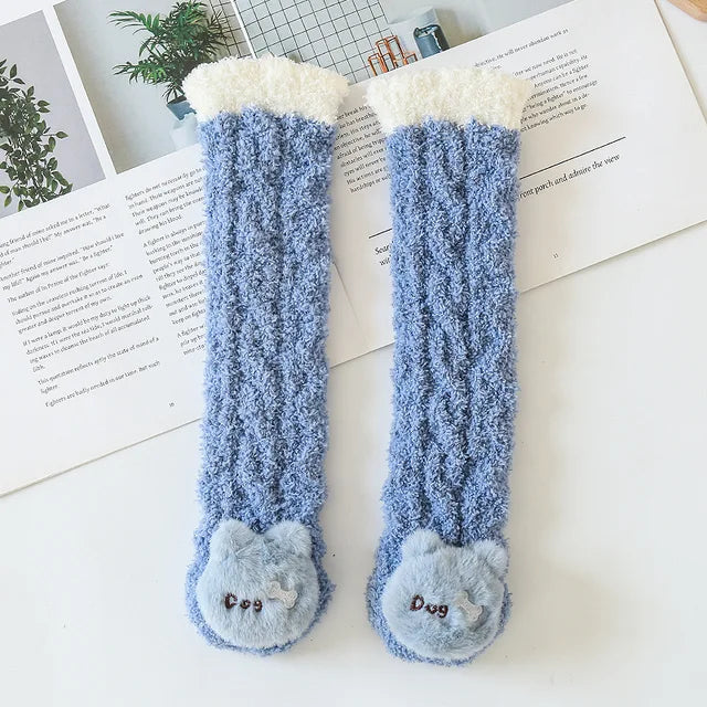 Blue dog socks laid flat to show their long shape and fuzzy texture