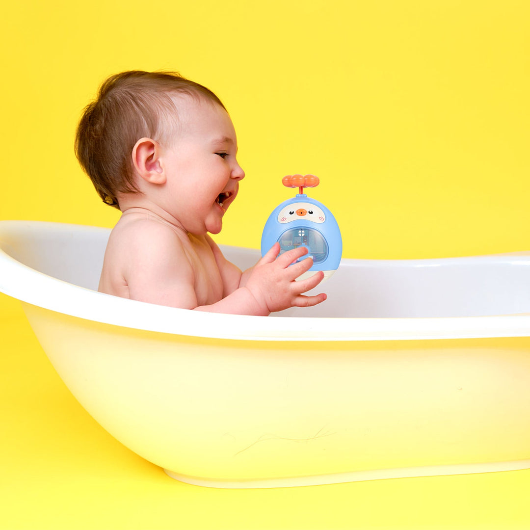 Child holding a blue duck-shaped bath toy in a white bathtub against a yellow background