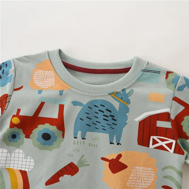 Close-up of the ribbed crew neck and colorful farm print on the blue-green sweatshirt