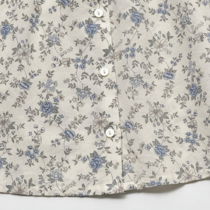 Detail of the blue floral fabric, button front, and hem of the children&